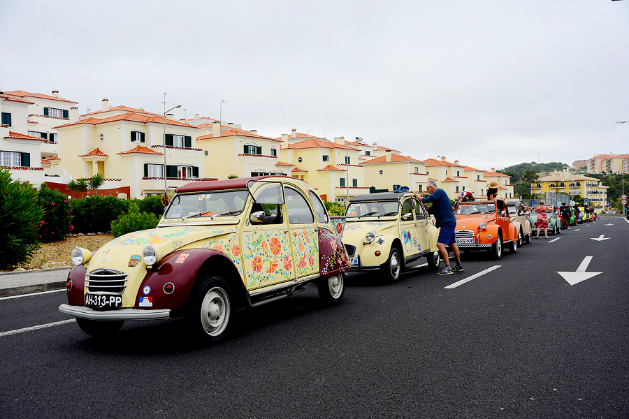 Desfile de Citroën 2CV numa vila