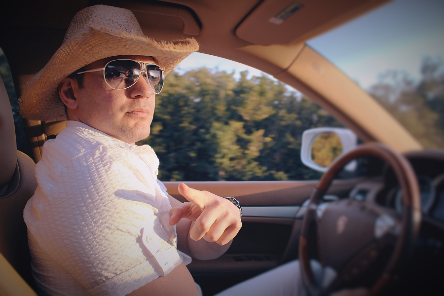 Homem com chapéu de palha e óculos de sol a conduzir