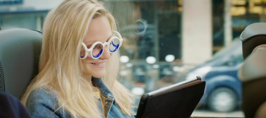 Mulher com óculos Seetroën a ler um livro durante viagem de carro