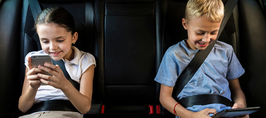 Crianças com smartphones no carro